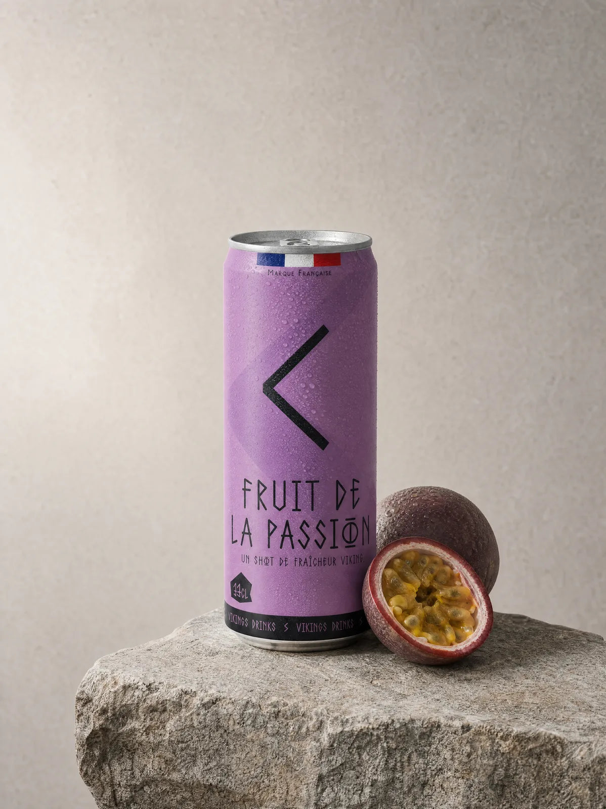 Canette Fruit de la Passion posée sur la pierre, ses fruits frais à côté