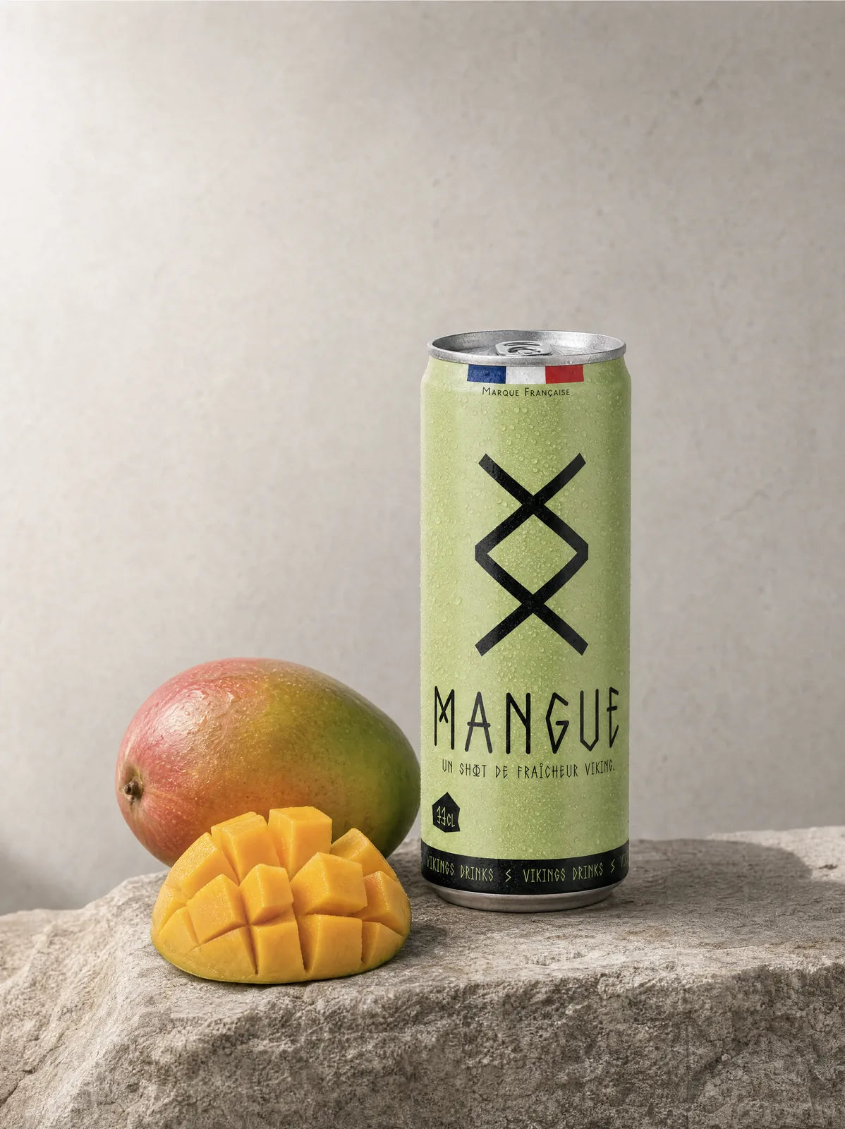 Canette Mangue posée sur la pierre, ses fruits frais à côté